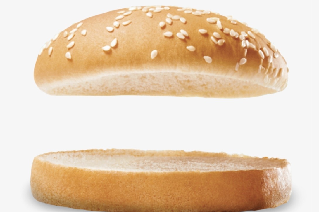 A sesame bun, top and bottom, floating apart