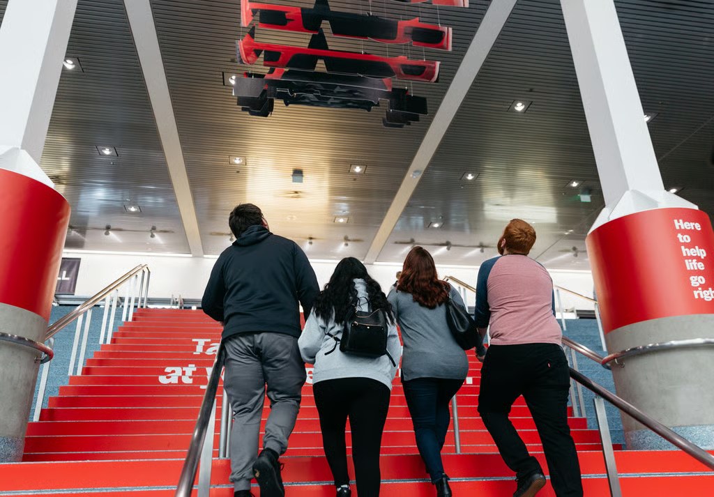 Attendees climbing the staircase under the suspended car